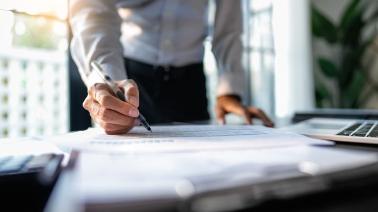 uomo scrive degli indicatori finanziari relativi alla gestione della crisi di impresa preventiva