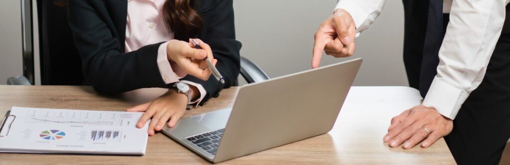 due persone indicano il computer per capire come semplificare la tesoreria aziendale