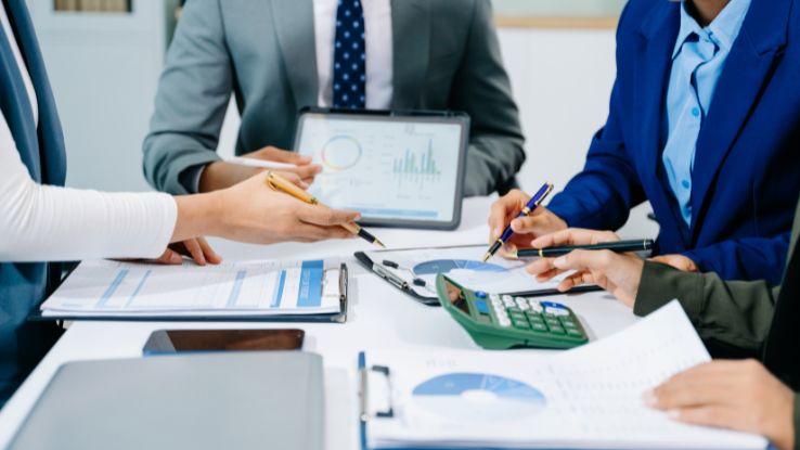 persone compilano il budget di tesoreria in ufficio