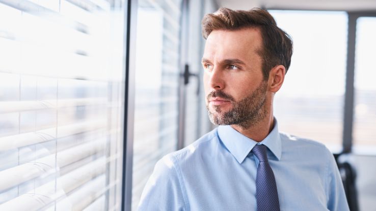 uomo con sguardo pensieroso in azienda